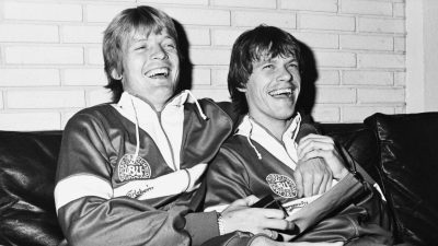 Søren Lerby og Frank Arnesen i højt humør ved landsholdets pressemøde på Hotel Marina i Vedbæk dagen inden VM-kvalifikationskampen mod Irland i 1984. De to fodboldspillere spillede sammen i barndomsklubben Fremad Amager og blev solgt samtidig til Ajax Amsterdam i 1975. Sidenhen afsluttede de begge karrieren i PSV Eindhoven.